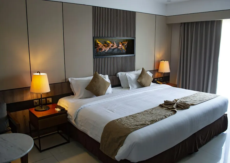 Prepared hotel guest room with a double bed and bedside lamps