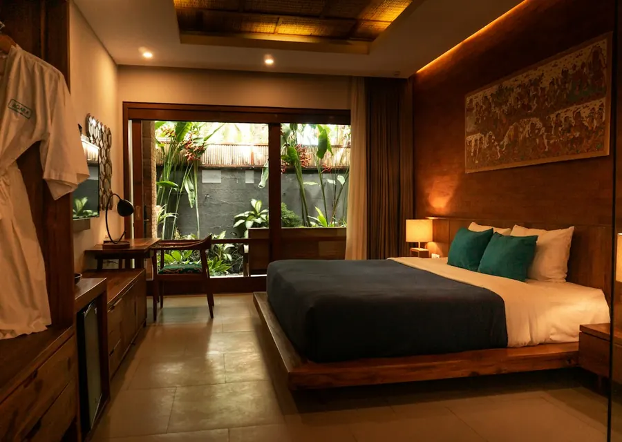 Hotel room with warm wood finishes and garden view